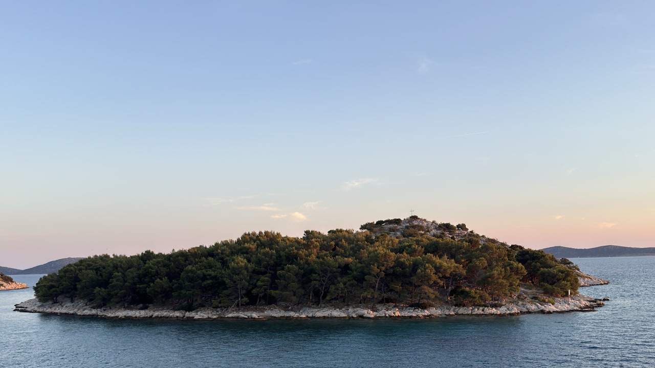 Šumoviti otok kraj Tribunja u sumrak